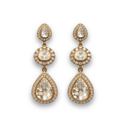 Gold teardrop earrings with clear gemstones on a white background